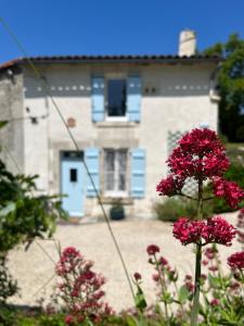 Saint-Romain的住宿－La Colline de Tilleul - Les Tilleuls - Pretty cottage near Aubeterre in idyllic location，前面有粉红色花的房子