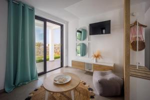 a living room with a table and a large window at Hermagio Villa Mary by Estia in Malia