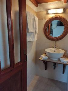 a bathroom with a sink and a mirror at Sunset Apartment in Patmos