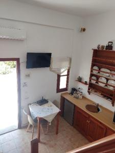 een keuken met een tafel en een wastafel in een kamer bij Sunset Apartment in Patmos