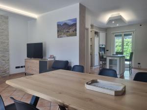 uma sala de estar com uma mesa e cadeiras e uma televisão em Suite vacanze Chabloz nel cuore della Valle d'Aosta em Nus