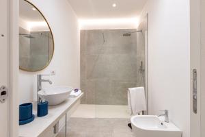 a white bathroom with a sink and a shower at Baia del Sole in Olbia