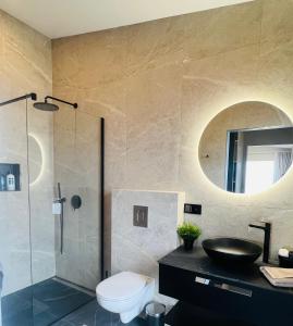 y baño con lavabo, aseo y espejo. en Luxury villa with hot tub & amazing view, en Reykholt