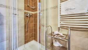 a bathroom with a shower with a tub and a sink at VisitZakopane - City Apartments in Zakopane