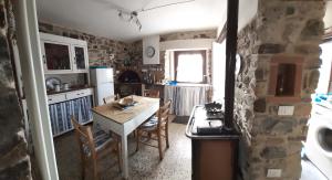 - une cuisine avec une table et un mur en pierre dans l'établissement Montedivalli, à Montedivalli Chiesa