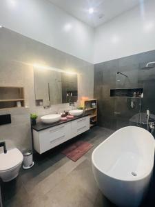 a bathroom with two sinks and a tub and two toilets at Luxury villa with hot tub & amazing view in Reykholt