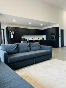 un soggiorno con divano blu e una cucina di Luxury villa with hot tub & amazing view a Reykholt