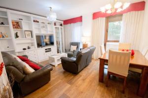 uma sala de estar com um sofá, cadeiras e uma mesa em For Your Rentals Nice And Cozy Apartment Near Isla Azul-Madrid ATA5D em Madri