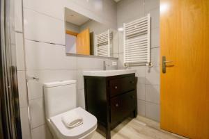 uma casa de banho com um WC, um lavatório e um espelho. em For Your Rentals Nice And Cozy Apartment Near Isla Azul-Madrid ATA5D em Madri