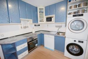 uma cozinha com armários azuis e uma máquina de lavar roupa em For Your Rentals Nice And Cozy Apartment Near Isla Azul-Madrid ATA5D em Madri