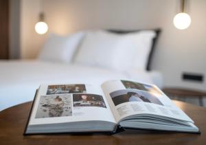 an open book on a table with a bed at Mythodea Athens Suites in Athens