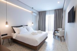 una camera d'albergo con un letto, un tavolo e delle sedie di Mythodea Athens Suites ad Atene