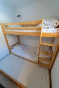 two bunk beds in a room with a ladder at Les Saisies appart 1 chambre au pied des pistes in Les Saisies