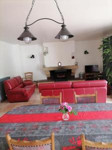 salon z czerwoną kanapą i stołem w obiekcie La Maison de Raph w mieście Villeneuve dʼOlmes