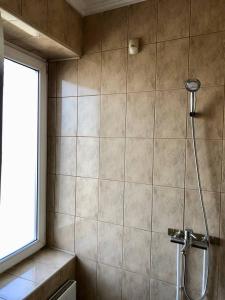 a shower in a bathroom with a tile wall at Easy Hostel in Chernivtsi