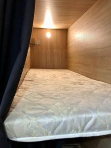 a bed in a room with a wooden wall at Easy Hostel in Chernivtsi