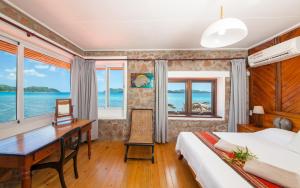 a hotel room with a desk and a bed at La Saline in Praslin