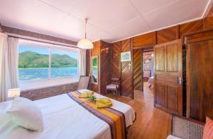 a bedroom with a bed and a large window at La Saline in Praslin
