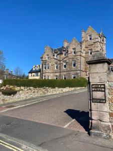 a large stone building with a sign in front of it at Golf Court View, Elie in Elie