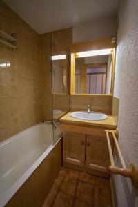 a bathroom with a sink and a tub and a mirror at Les Saisies appart 1 chambre au pied des pistes in Les Saisies