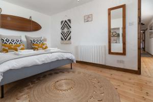a bedroom with a large bed and a mirror at Porthcurno Barns, The Big Barn - Spacious & cosy cottage, walk to Porthcurno beach, Pedn Vouder & Minack Theatre in Penzance