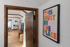 a picture hanging on a wall next to a door at Porthcurno Barns, The Big Barn - Spacious & cosy cottage, walk to Porthcurno beach, Pedn Vouder & Minack Theatre in Penzance