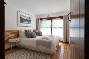a bedroom with a large bed and a window at Porthcurno Barns, The Big Barn - Spacious & cosy cottage, walk to Porthcurno beach, Pedn Vouder & Minack Theatre in Penzance