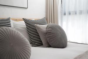 a white bed with two pillows and a window at Porthcurno Barns, The Big Barn - Spacious & cosy cottage, walk to Porthcurno beach, Pedn Vouder & Minack Theatre in Penzance