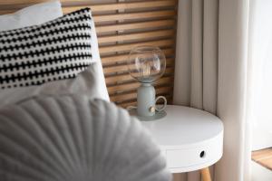 a bedroom with a bed with a lamp on a nightstand at Porthcurno Barns, The Big Barn - Spacious & cosy cottage, walk to Porthcurno beach, Pedn Vouder & Minack Theatre in Penzance