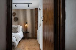 a bedroom with a bed and a table with a lamp at Porthcurno Barns, The Big Barn - Spacious & cosy cottage, walk to Porthcurno beach, Pedn Vouder & Minack Theatre in Penzance