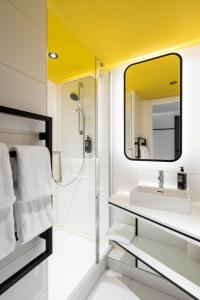 a bathroom with a sink and a shower at Adagio Access Gent Centrum Dampoort in Ghent