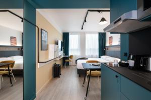 um quarto de hotel com duas camas e uma cozinha em Adagio Access Gent Centrum Dampoort em Gent