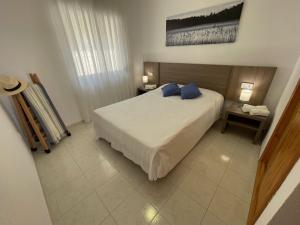 a bedroom with a large white bed with blue pillows at Pool paradise in Calpe +29 photos
