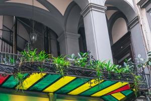 uma varanda com plantas num vaso colorido em La Smorfia em Nápoles