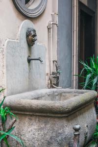 uma estátua de uma cabeça numa banheira de pedra em La Smorfia em Nápoles