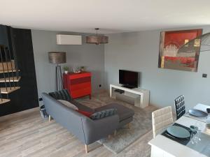 a living room with a couch and a tv at La bulle beaujolaise in Juliénas