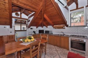 een keuken met een houten tafel en een fruitschaal bij Luna Rossa in Minori