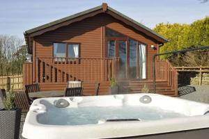 a bath tub in front of a tiny house at Lochhill Stable Lodge in Castle Douglas