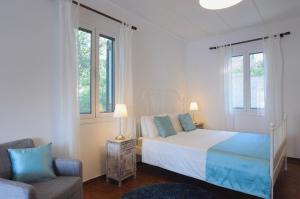 Un dormitorio con una cama y un sofá y ventanas. en Stella Cottage, en Fiskardho