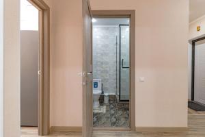 een badkamer met toilet en glazen deur bij Апартаменты в ЖК Only Sun - 3 in Astana +20 foto's