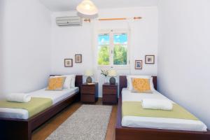 a bedroom with two beds and a window at The Bay House in Vathi, Ithaka +8 photos