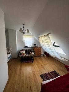 a attic room with a bed and a couch and a window at Dolinka Jantarowa in Jantar