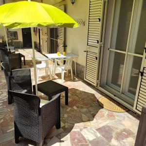 einen Tisch und Stühle mit gelbem Regenschirm auf einer Terrasse in der Unterkunft nonna rosa in Reggio di Calabria