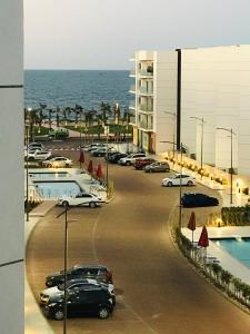 a parking lot with cars parked next to the ocean at Porto Said chalet rentals no123 in Port Said