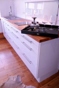 a kitchen with a sink and a counter with two wine glasses at Die Mühle Appartements in Samtens