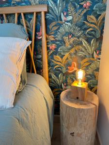 une lampe sur une table à côté d'un lit dans l'établissement Appartement Le Fayot, à Wimereux