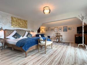 ein Schlafzimmer mit einem großen Bett mit einer blauen Decke in der Unterkunft Sieben Zimmer am See in Prien am Chiemsee