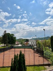 a tennis court with two tennis courts at Pensiunea Longocampo in Cîmpulung