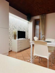 Una sala de estar con televisión, mesa y sillas. en V HOME, en Biella