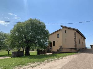an old building on the side of a dirt road at Casa Vella del Cuní in Roda del Ter